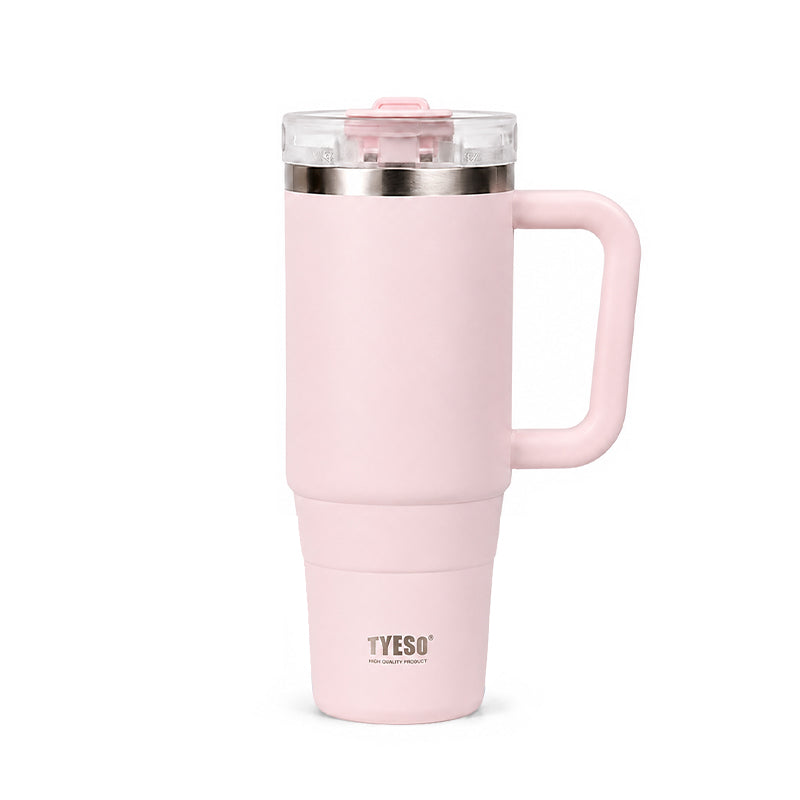 Blush pink ceramic tumbler with clear lid, metal rim, and side handle